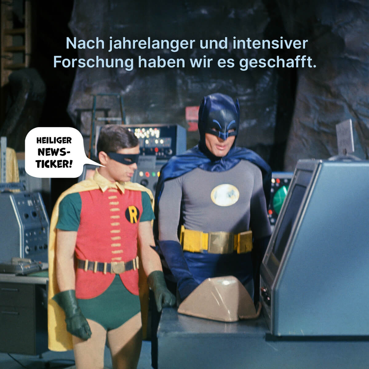 Batman und Robin schauen auf einen Bildschirm in der Bat-Höhle.